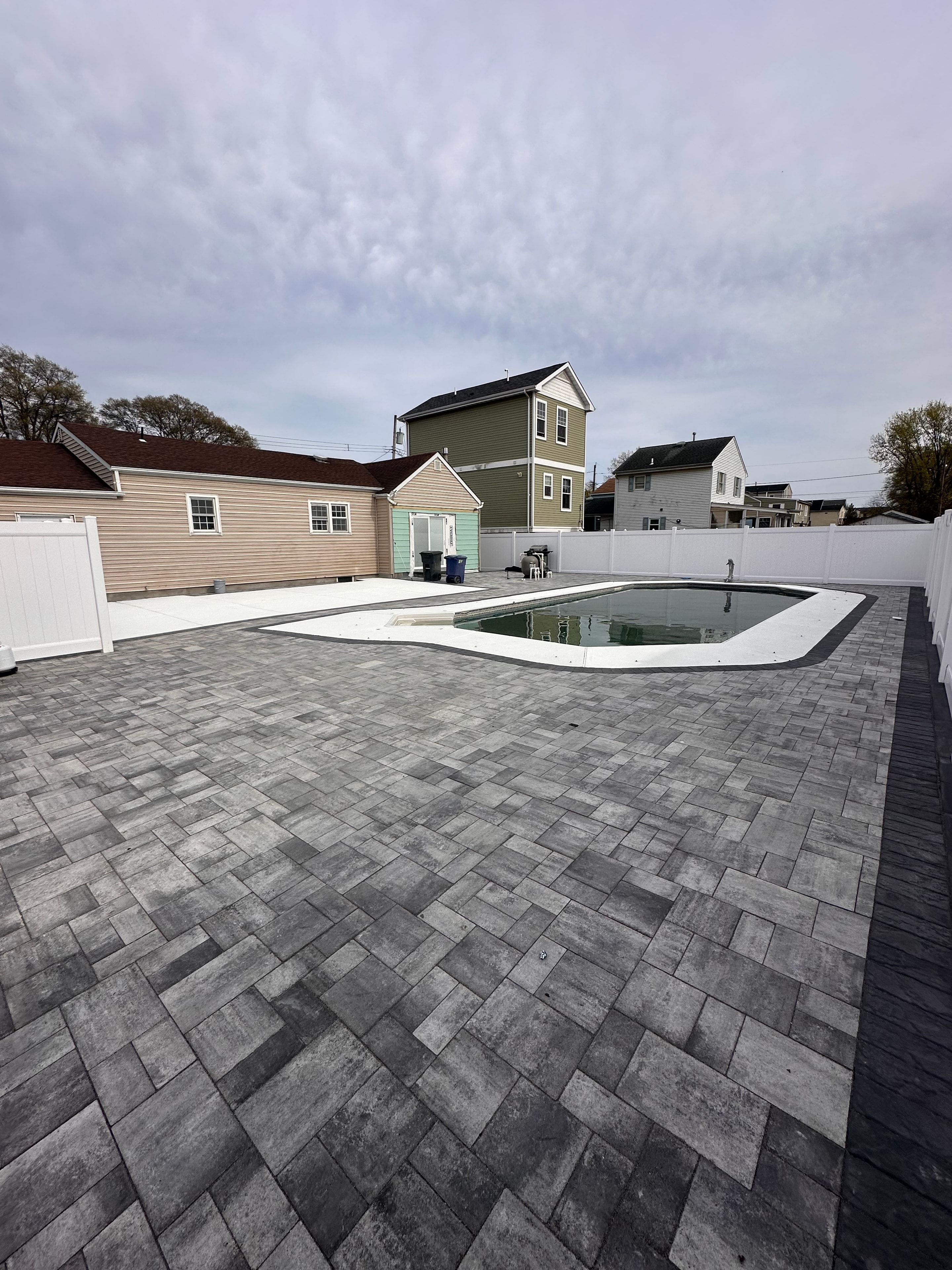 Completed paver patio and pool deck in New Jersey by HomeCraft Paving & Masonry